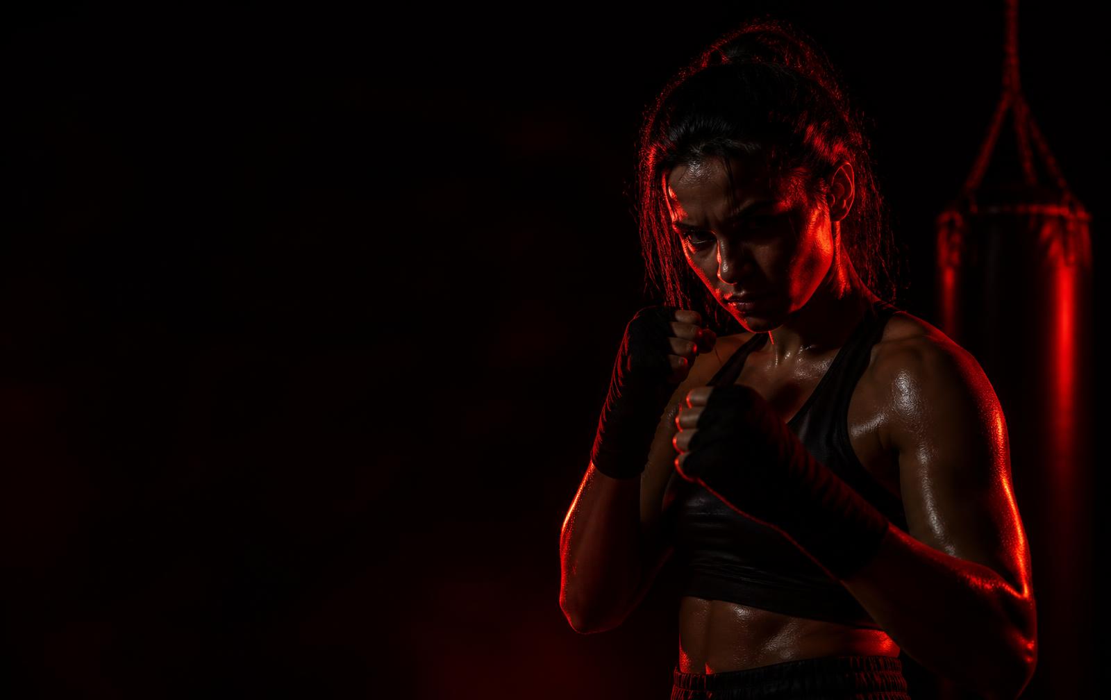 Athlete training in a dark gym lit with red light